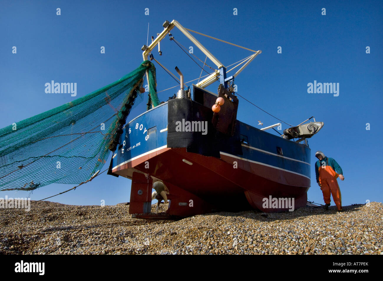 Un crewman dalla barca da pesca Roys ragazzi controlla i rulli come l'imbarcazione viene winched up Hastings beach Foto Stock