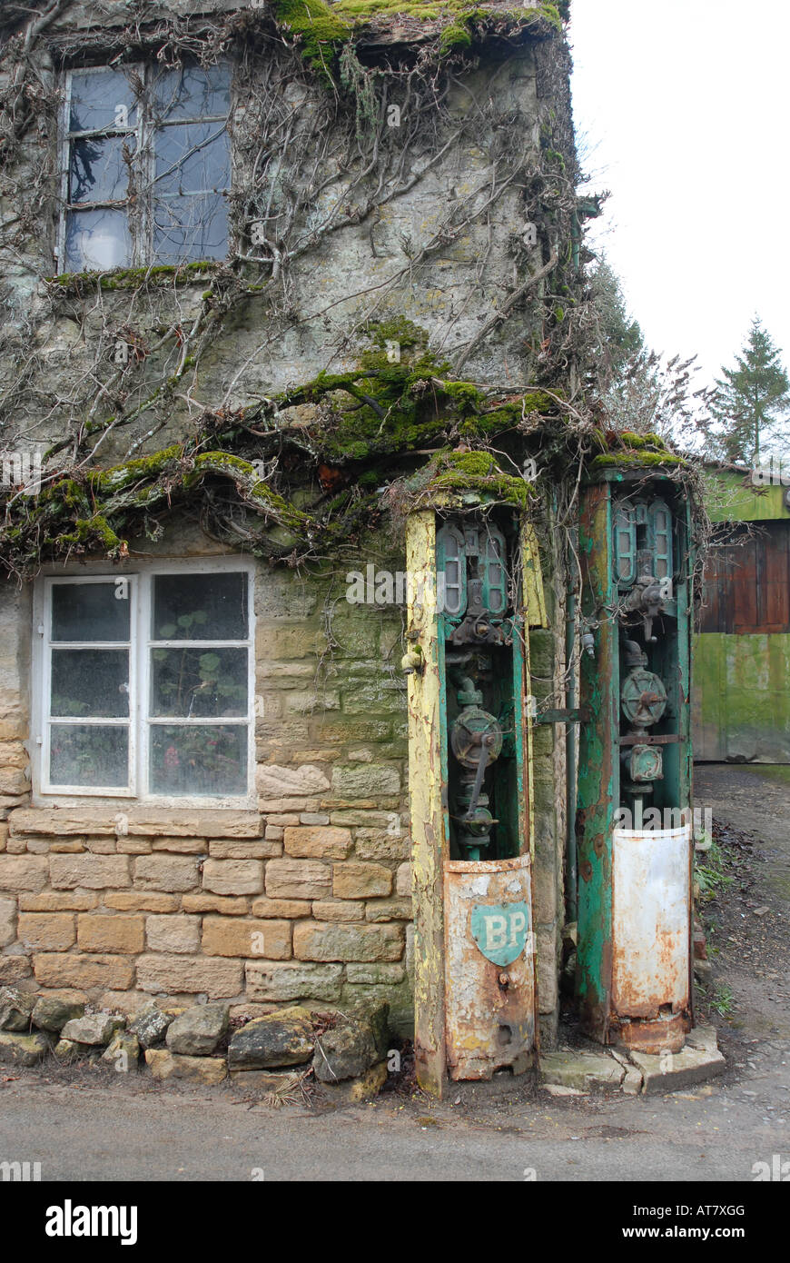 Vintage ridondanti le pompe di benzina a un ex stazione di benzina in un villaggio Costwold. Foto Stock