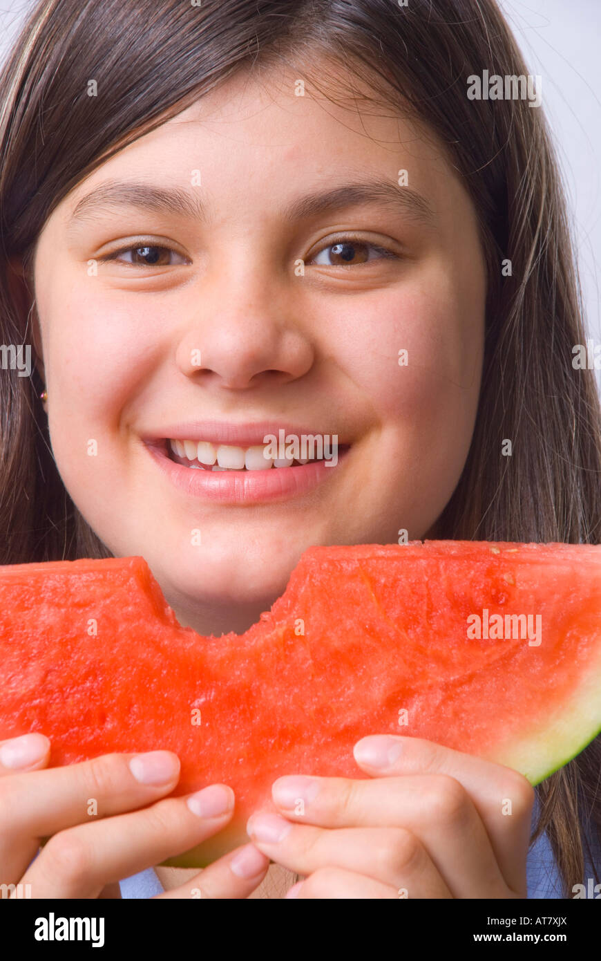 Giovane ragazza sorridente che mangia una fetta di anguria matura senza semi Foto Stock