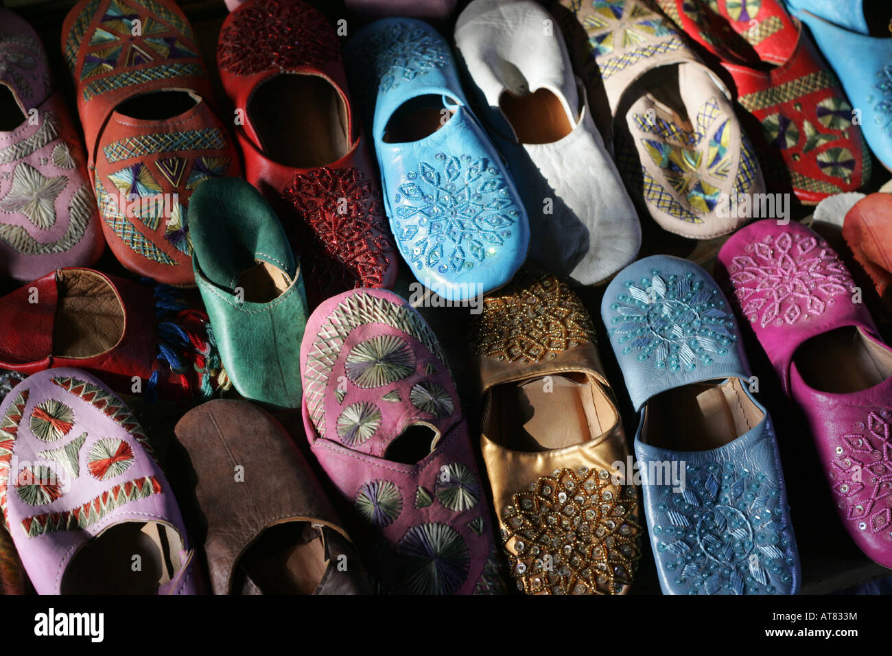Pantofole marocchino per la vendita in una fase di stallo in un suk, Medina, Marrakech, Marocco. Foto Stock
