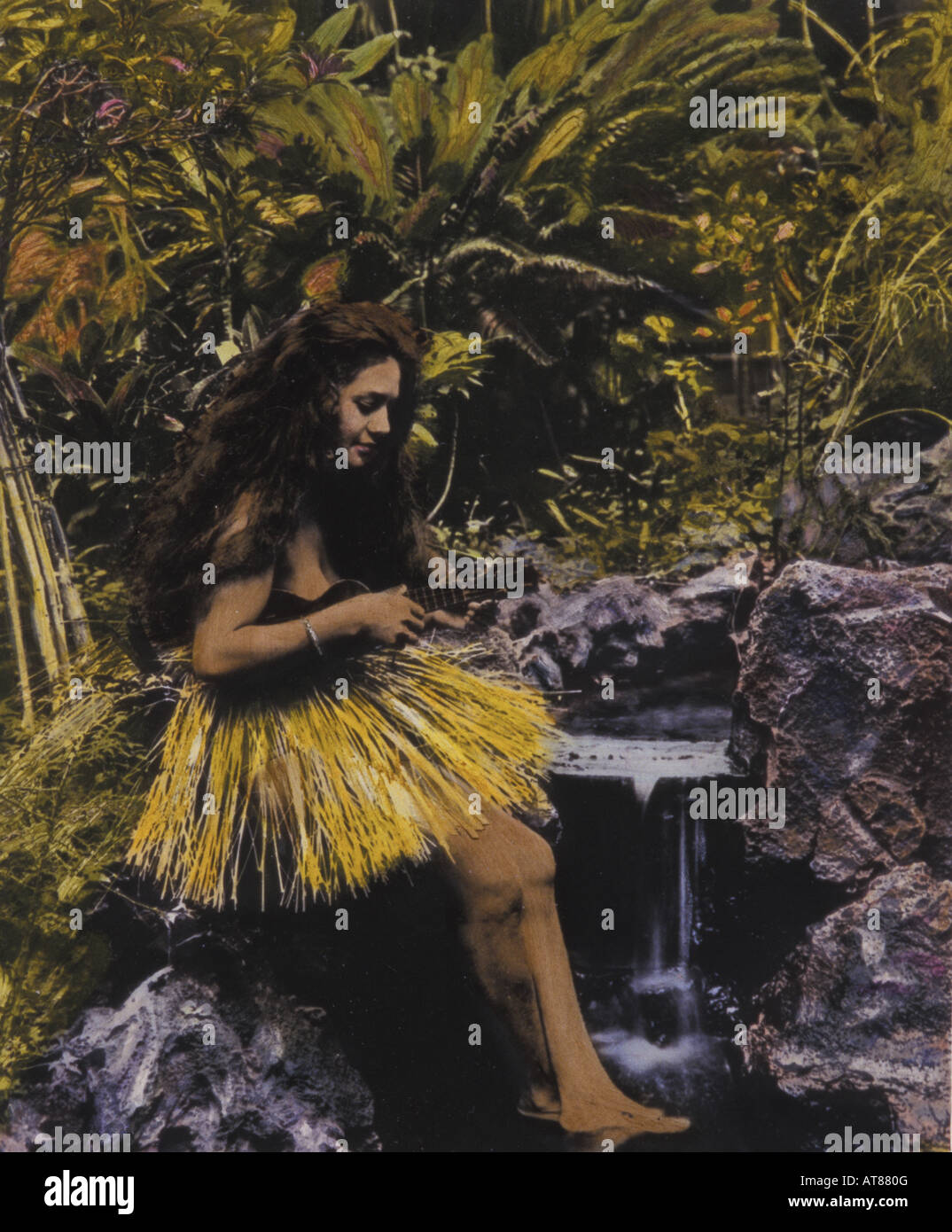 Mano-oscurata foto storiche di hula Hawaiana danzatore gioca il suo ukulele vicino a un ruscello Foto Stock