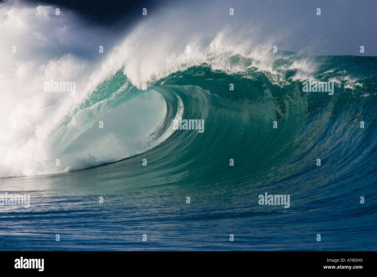 Bella grande onda con scogliera scura in background. Il Waimea Bay shore break sulla North Shore di Oahu, Hawaii. Foto Stock