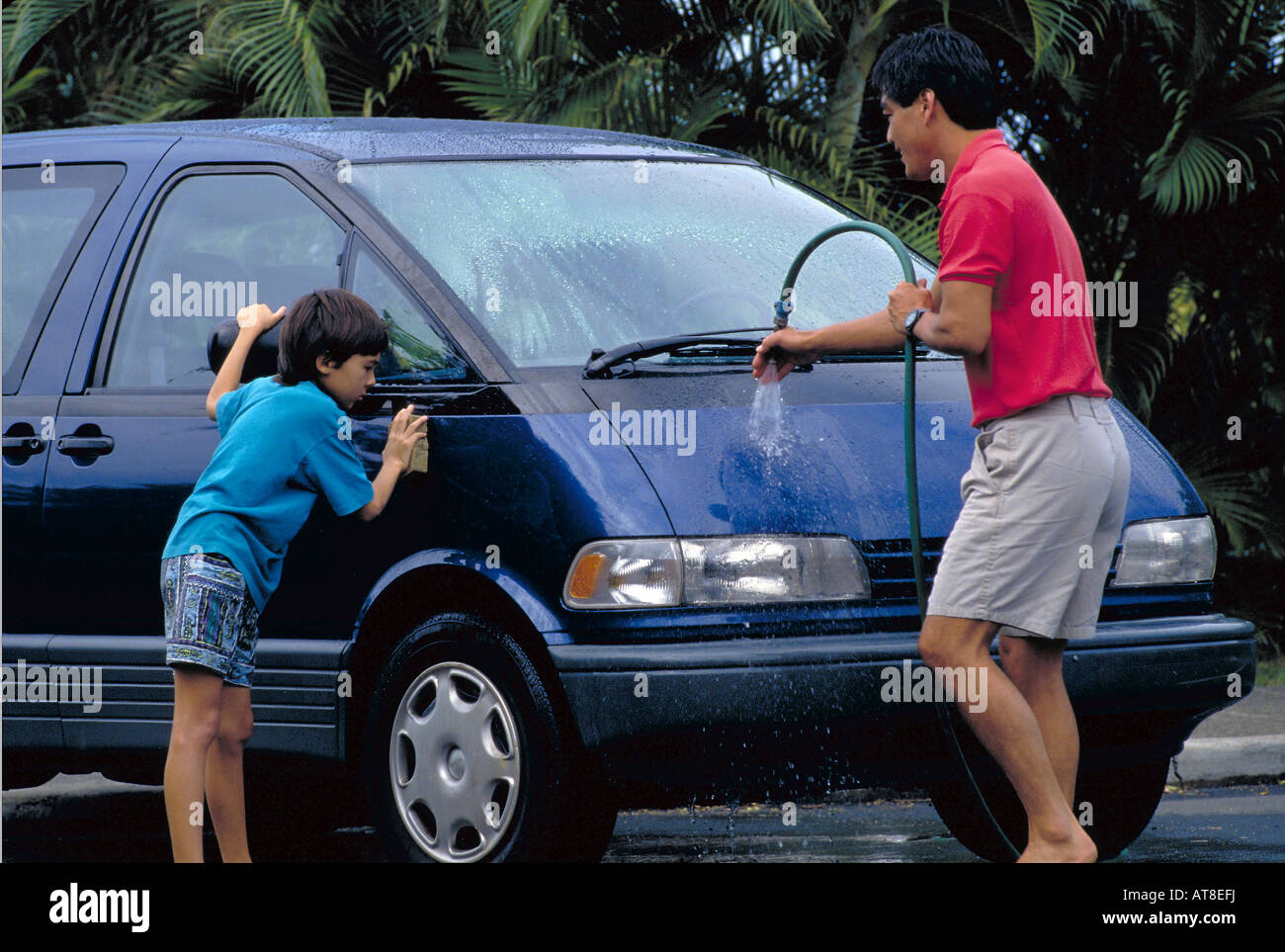 Americana giapponese padre e figlio auto lavaggio insieme. Foto Stock