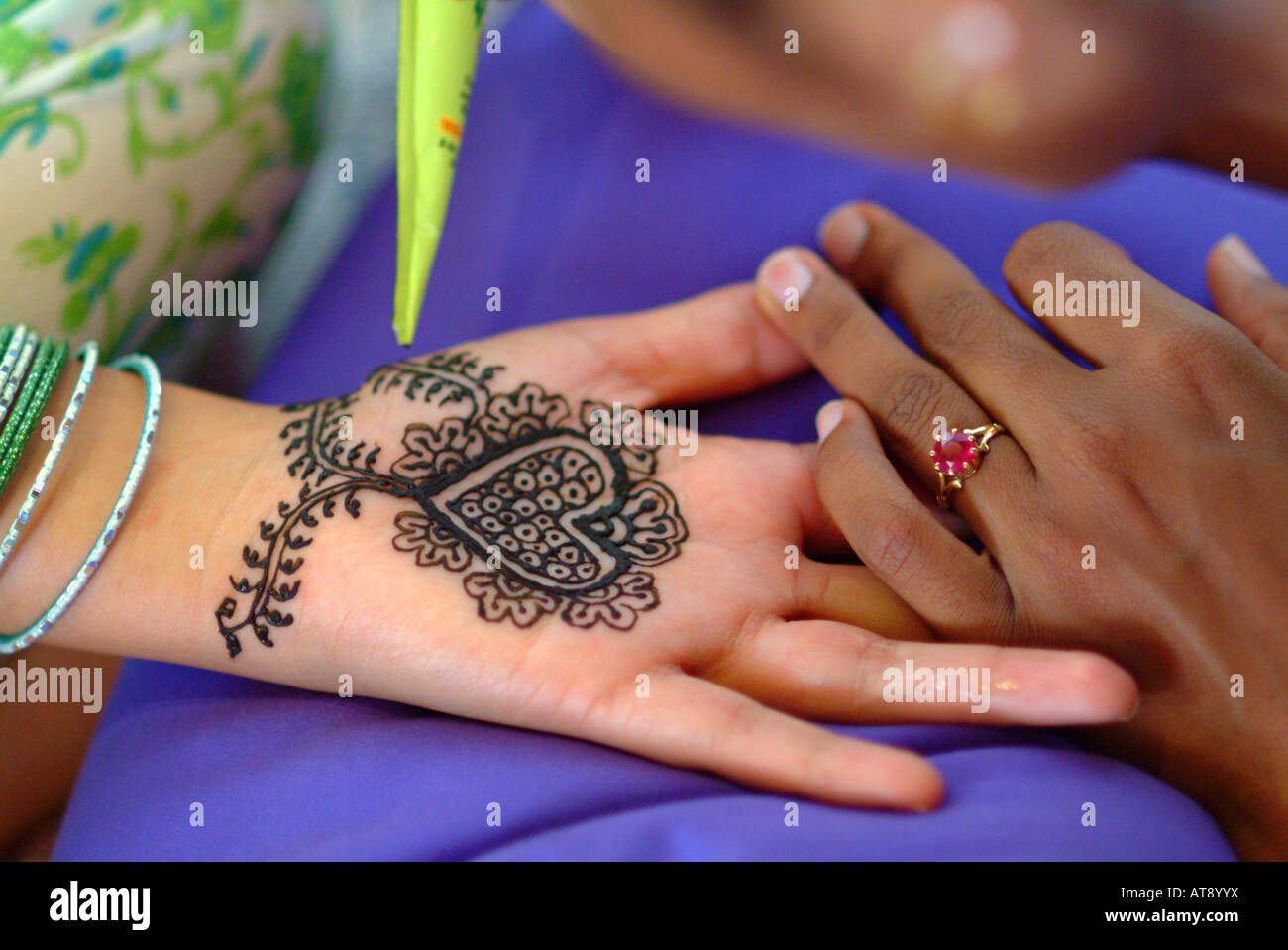 La donna riceve un mendhi henna design all'interno del palmo di una mano in preparazione per la sua hindi cerimonia di nozze Foto Stock