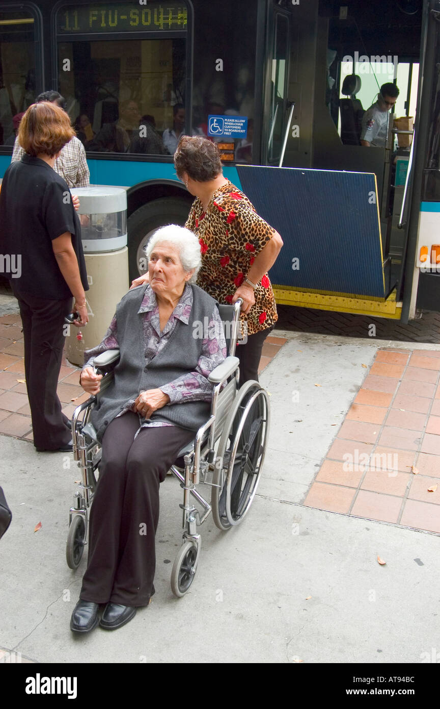 Miami Florida Street Life handicappati femmina Senior in carrozzella imbarco bus della città Foto Stock