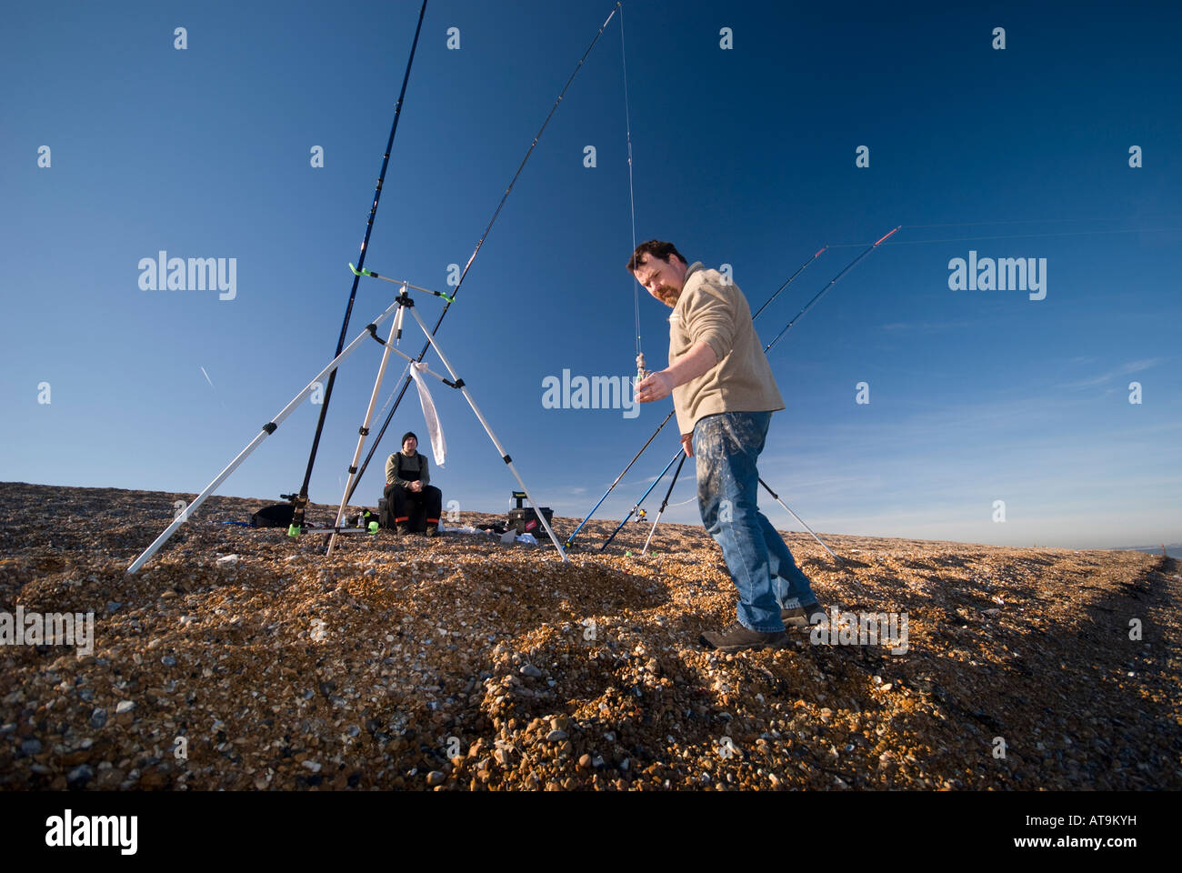 Pescatore sul litorale mettendo esca sulla linea, Sandwich Bay (nr trattativa), Kent, Regno Unito Foto Stock