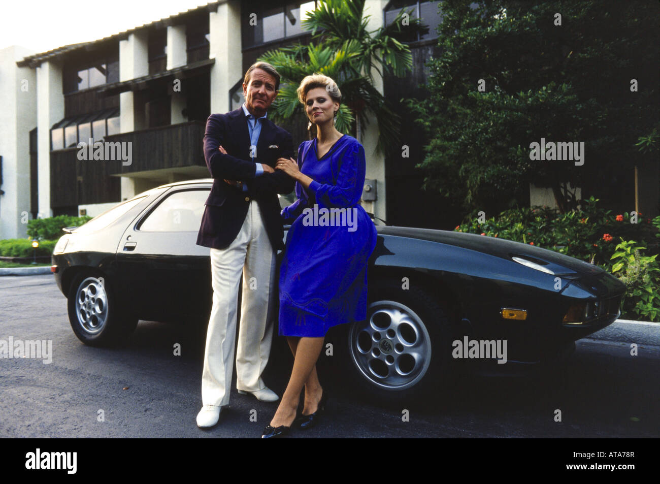 Elegante giovane con Porshe auto sportiva al di fuori del condominio. ritratto, Miami Foto Stock