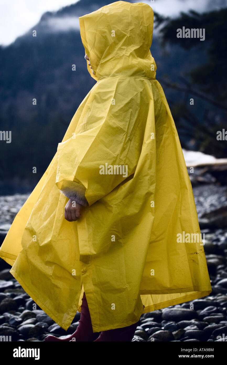 Bambino che indossa un poncho pioggia su una spiaggia ghiaiosa Foto stock -  Alamy