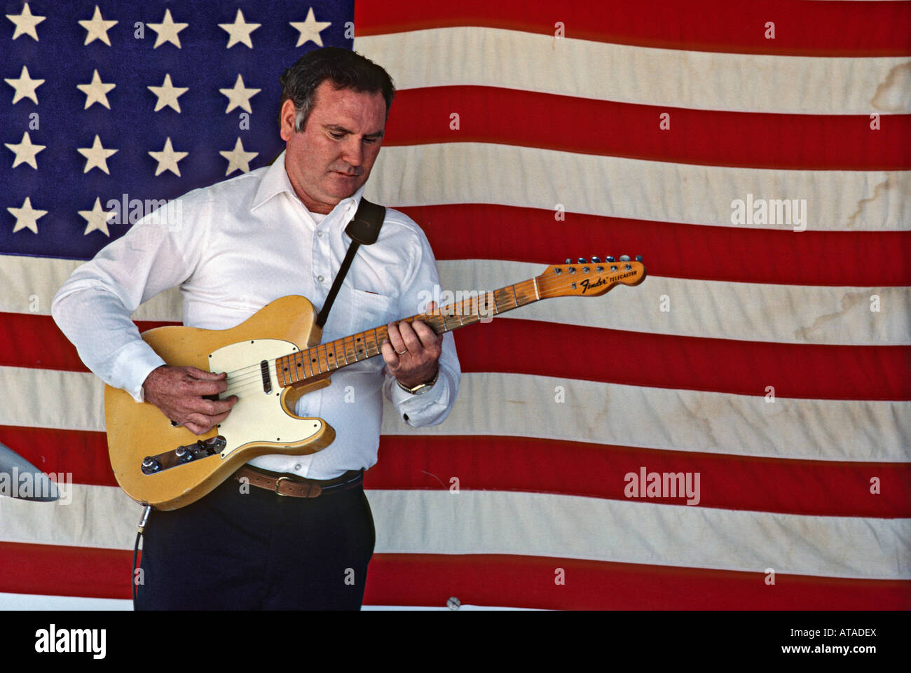 Paese chitarrista giocare davanti a una bandiera americana durante il gattuccio di mare Festival in Crescent City Florida USA Foto Stock