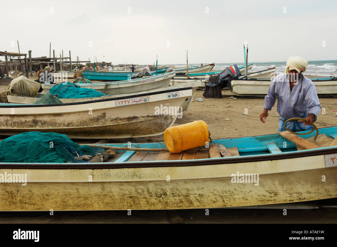 Fisherman e piccole barche da pesca Al Sawadi beach Oman Foto Stock