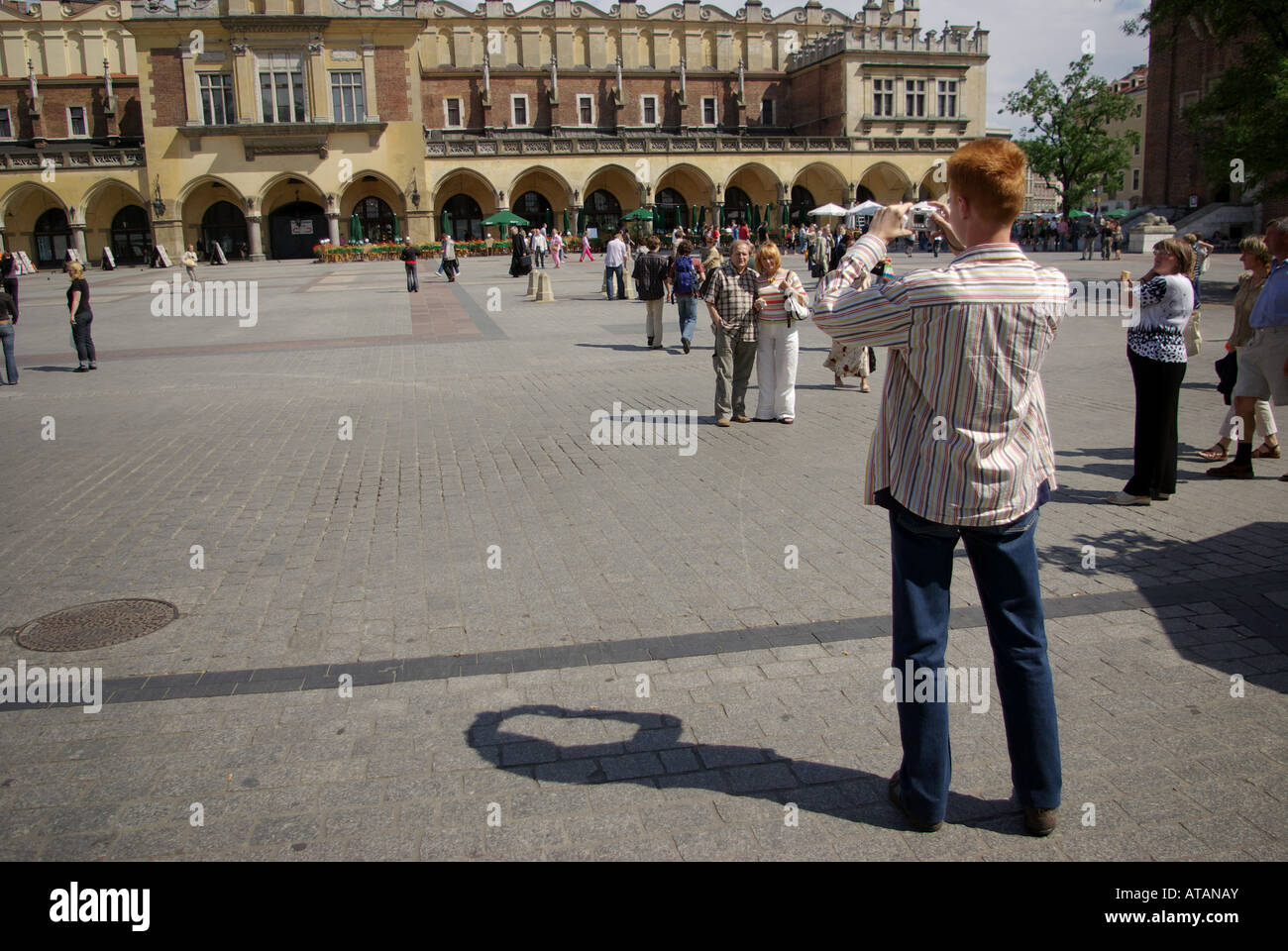 Cracovia, la piazza principale del mercato, giovane fotografa un paio in posa davanti il panno Hall Foto Stock