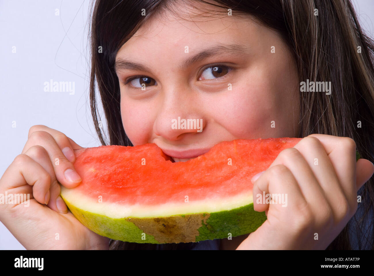 Giovane ragazza sorridente che mangia una fetta di anguria matura senza semi Foto Stock