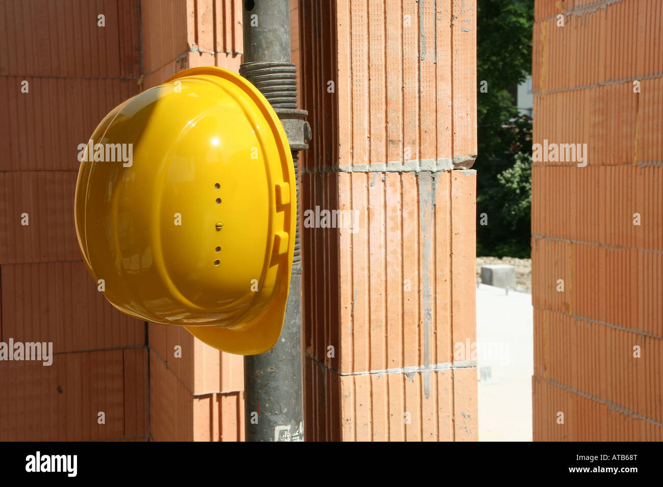 Giallo casco di lavoro su un sito di costruzione Foto Stock