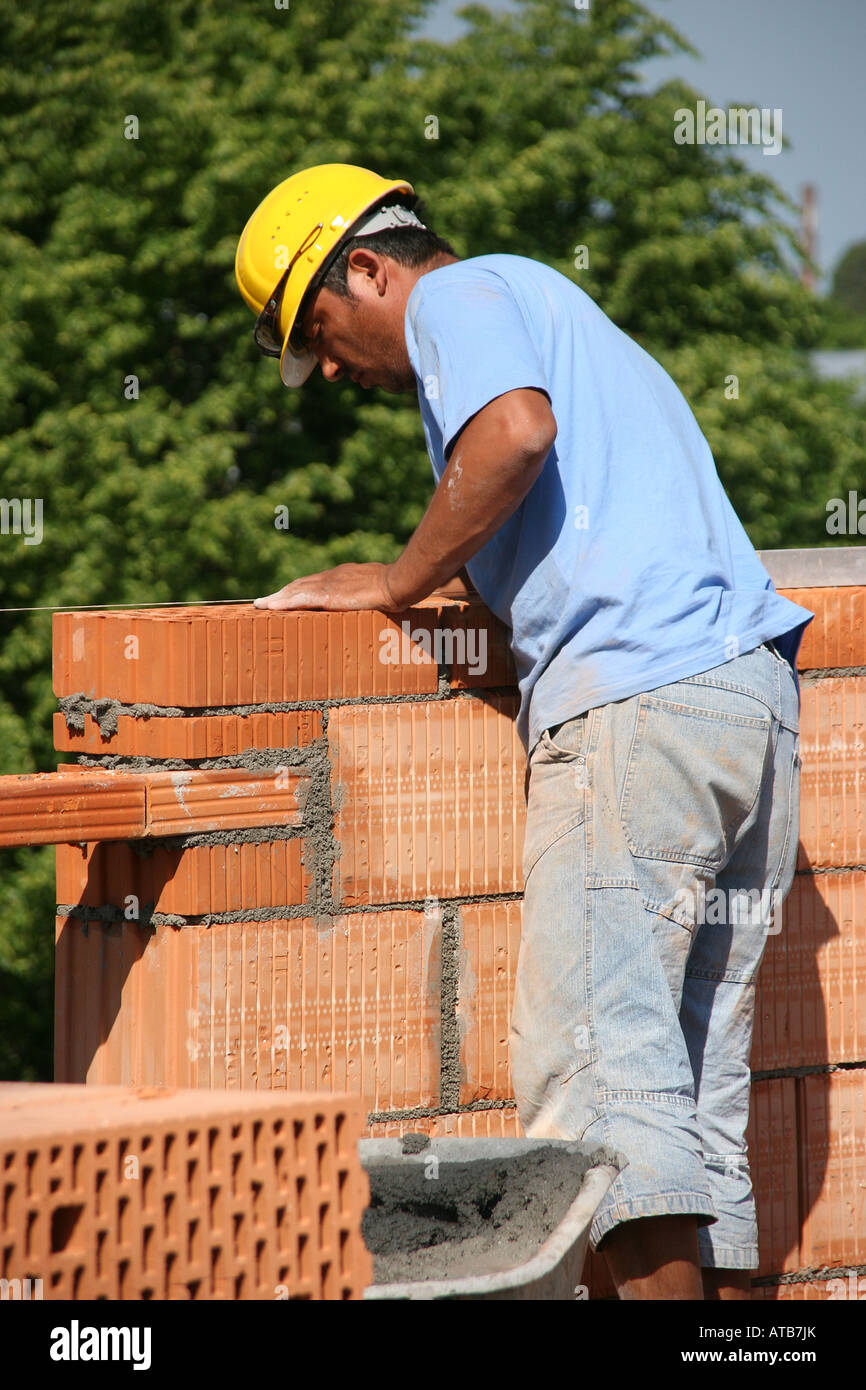 I lavoratori a costruire un muro di mattoni Foto Stock