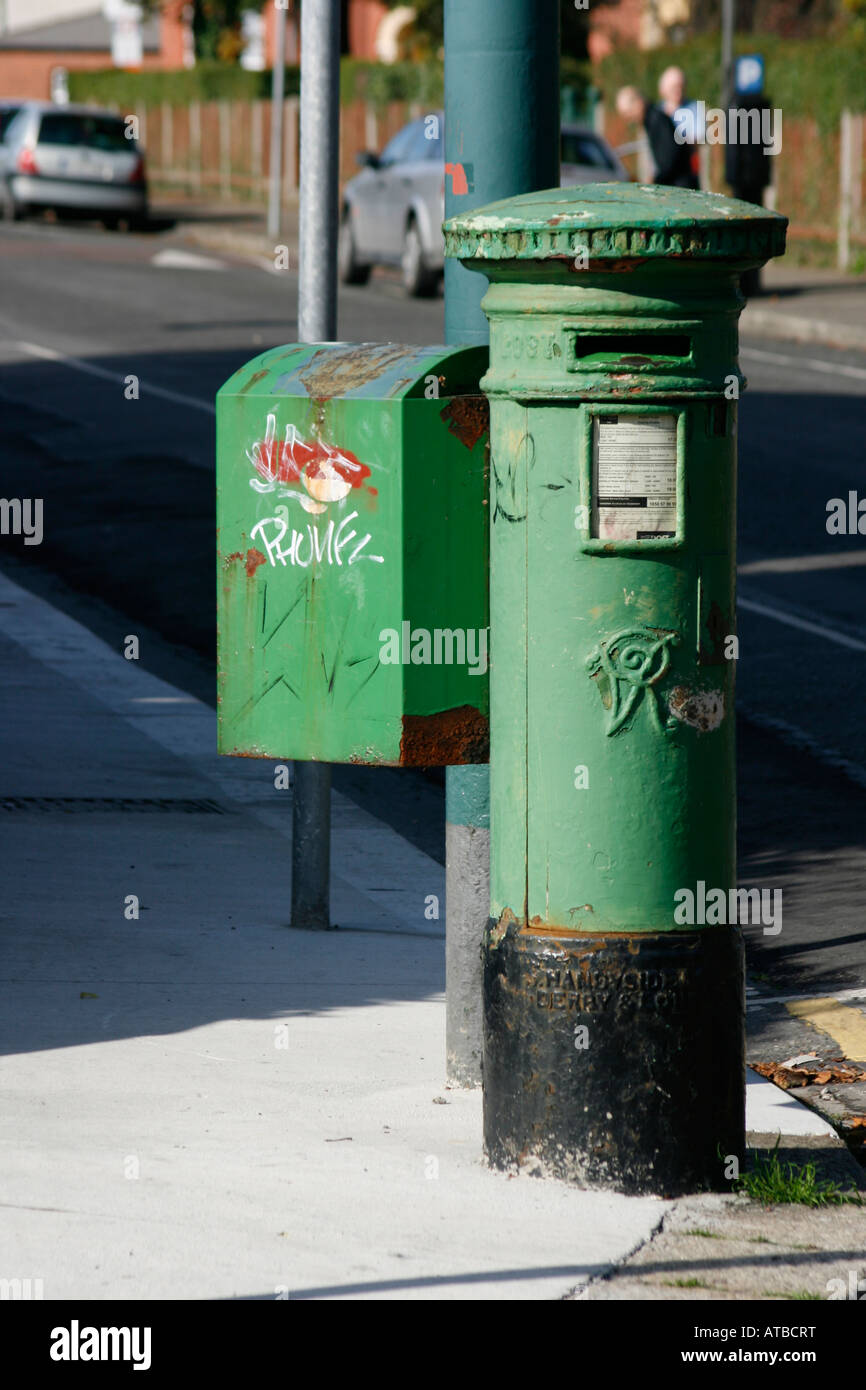 Irish post (e-mail) la casella su angolo di strada con la formazione di ruggine e graffiti Foto Stock