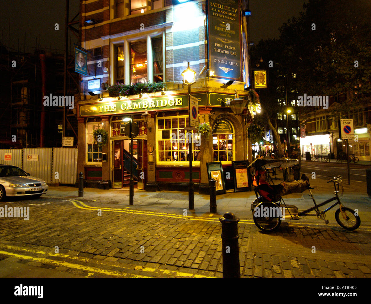 Rickshaw driver triciclo rilassarsi di fronte ad un pub di Soho su una tranquilla notte London REGNO UNITO Foto Stock