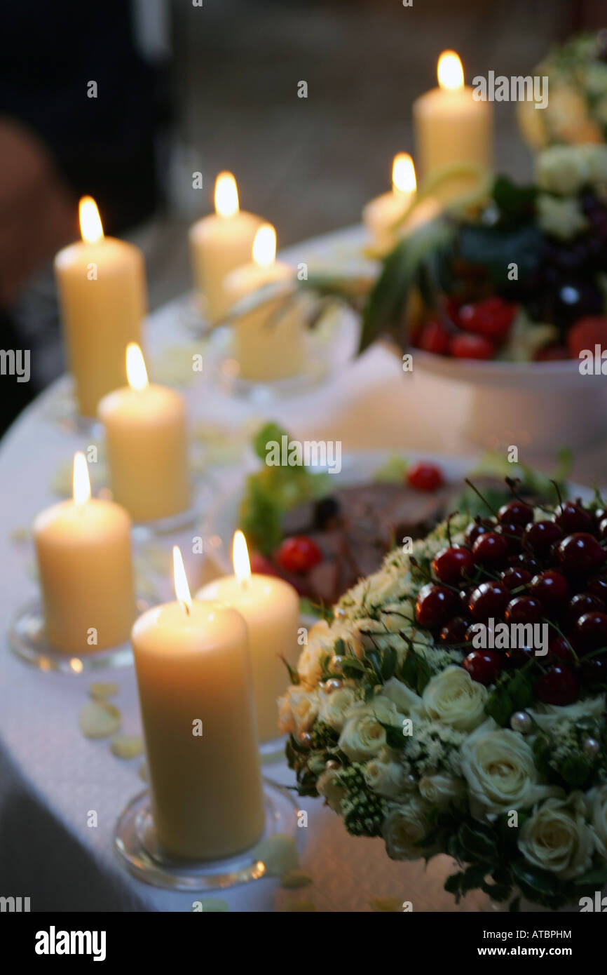 Alcune candele accese la masterizzazione su un tavolo a un ricevimento di nozze Foto Stock