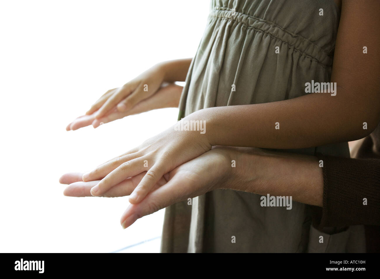 Donna che mantiene la ragazza le mani, vista ritagliata Foto Stock