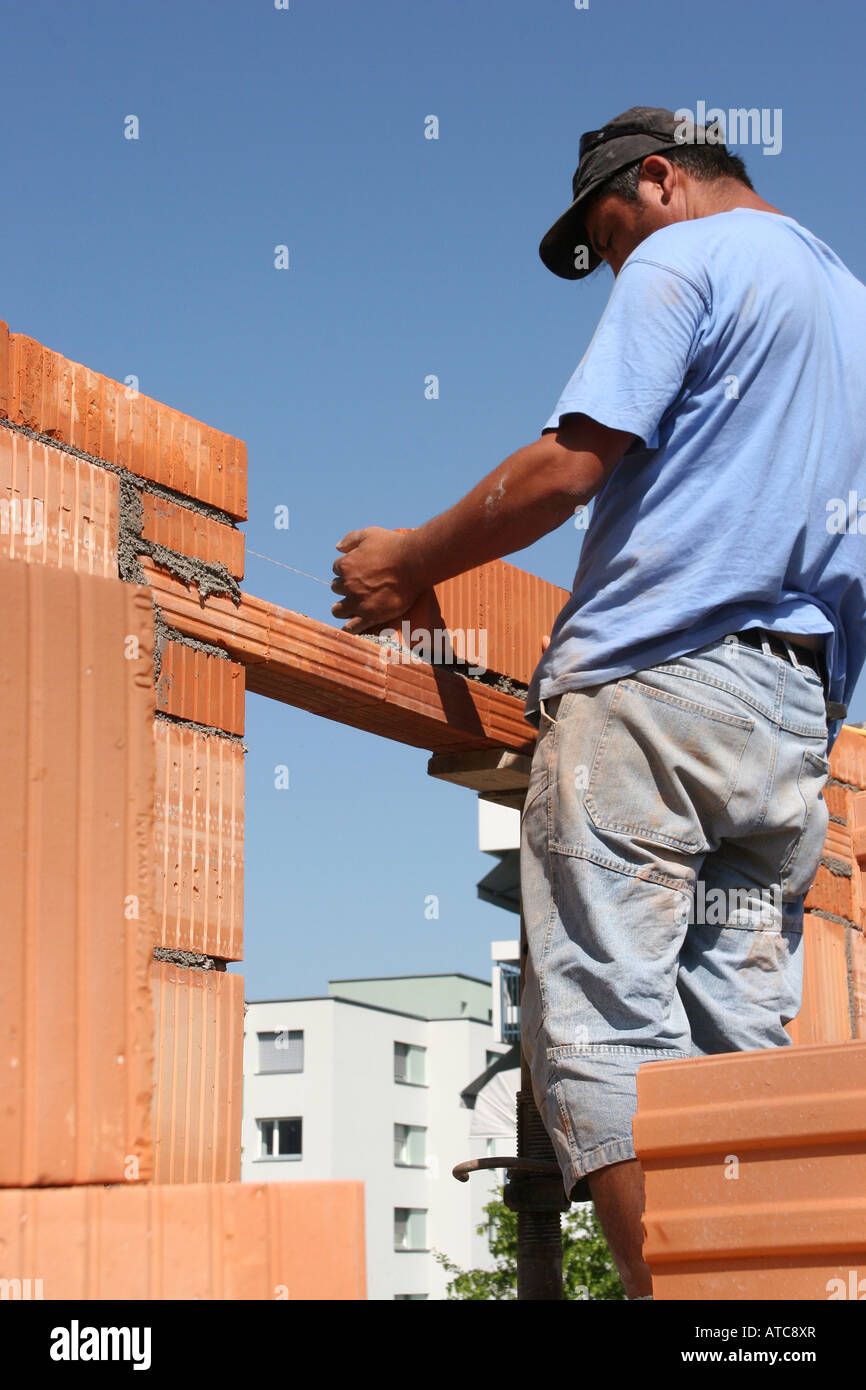 I lavoratori a costruire un muro di mattoni Foto Stock
