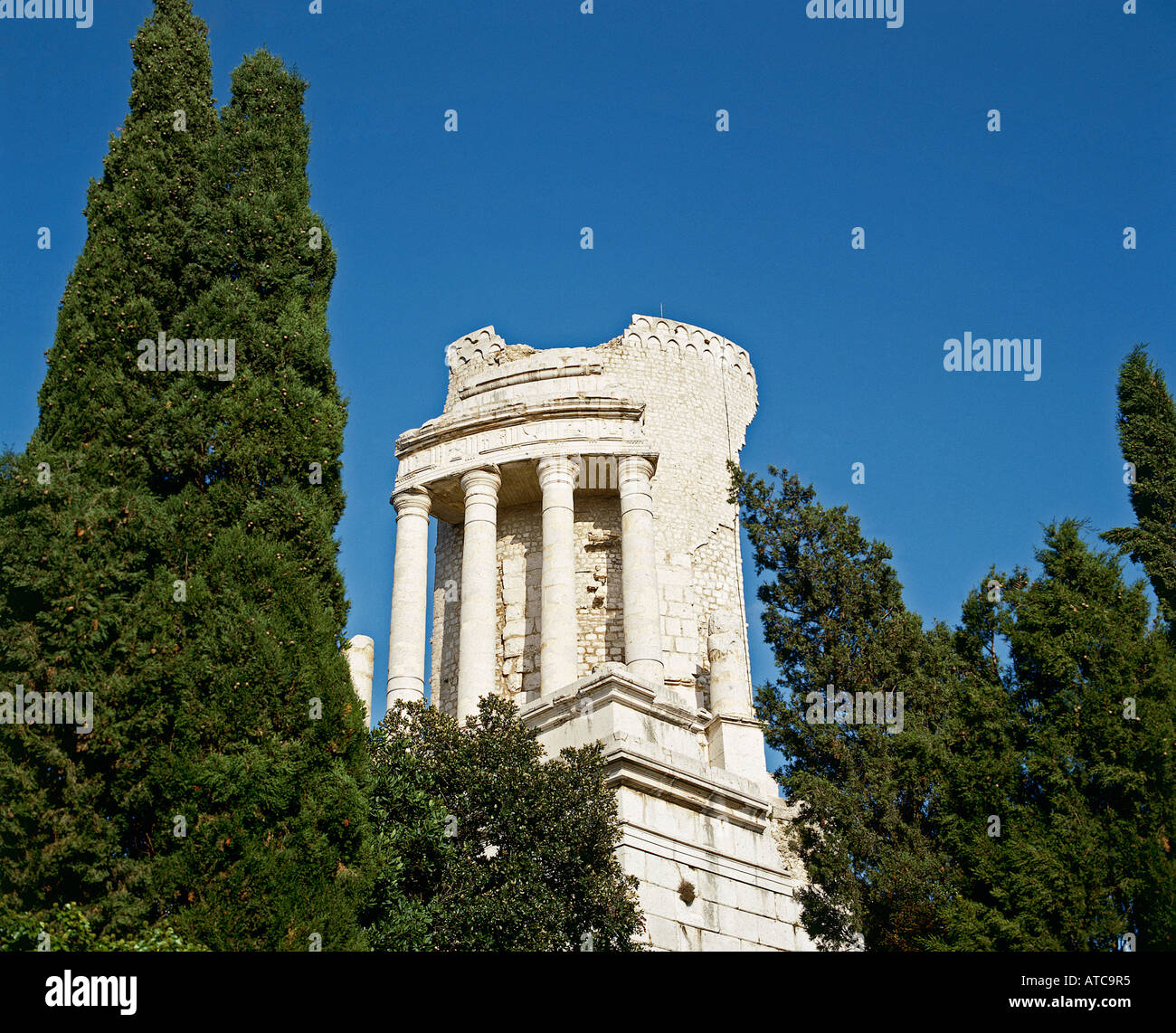 Alti cipressi incorniciano i resti del colonnato dorico incoronazione il restaurato Trophee des Alpes un monumento eretto nel VI secolo a.c. per commemorare le vittorie di Augusto oltre la tribù Alpina La Turbie Foto Stock