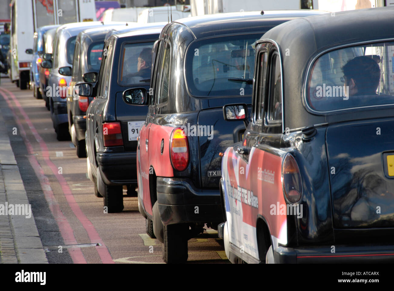Coda di nero Londra taxi nel traffico Foto Stock