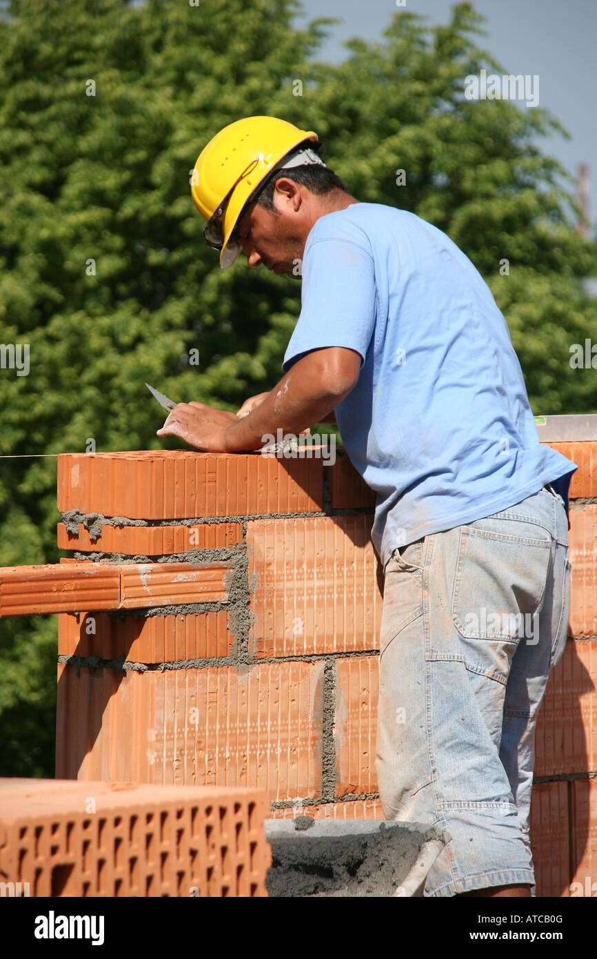 I lavoratori a costruire un muro di mattoni Foto Stock