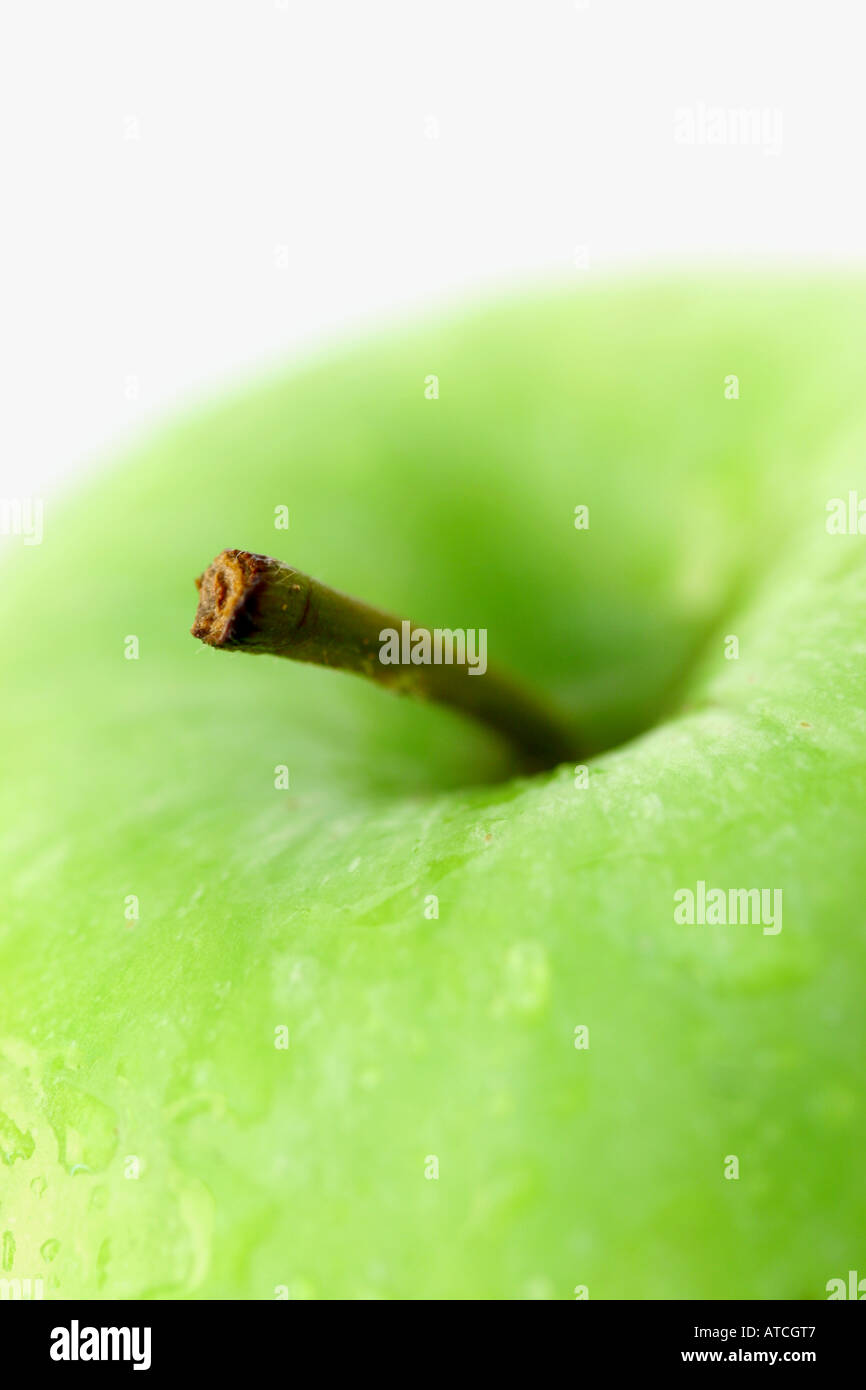 Mela Granny Smith verde fresca con gocce d'acqua su uno sfondo bianco tagliato da vicino Foto Stock