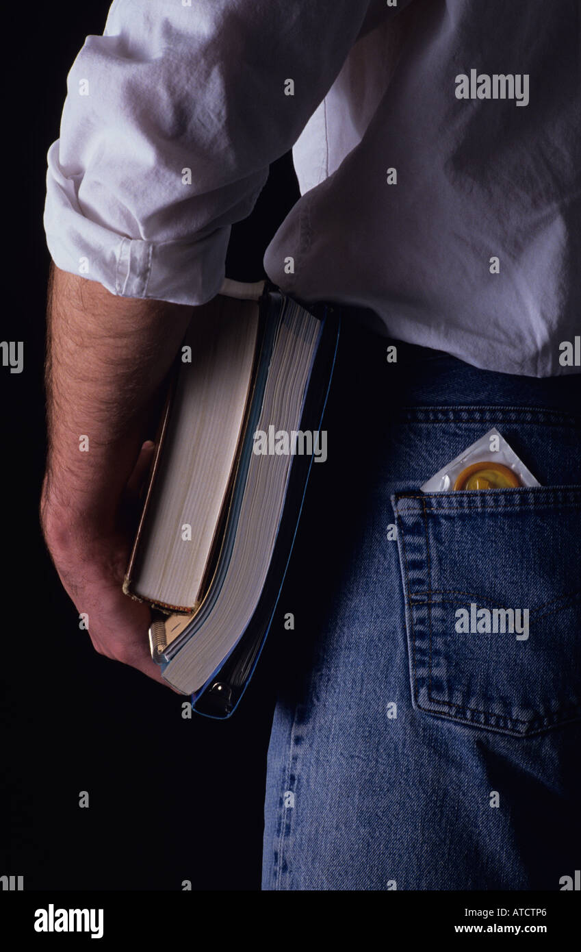Studente di college con libri con preservativo fuori della sua tasca posteriore MR Foto Stock