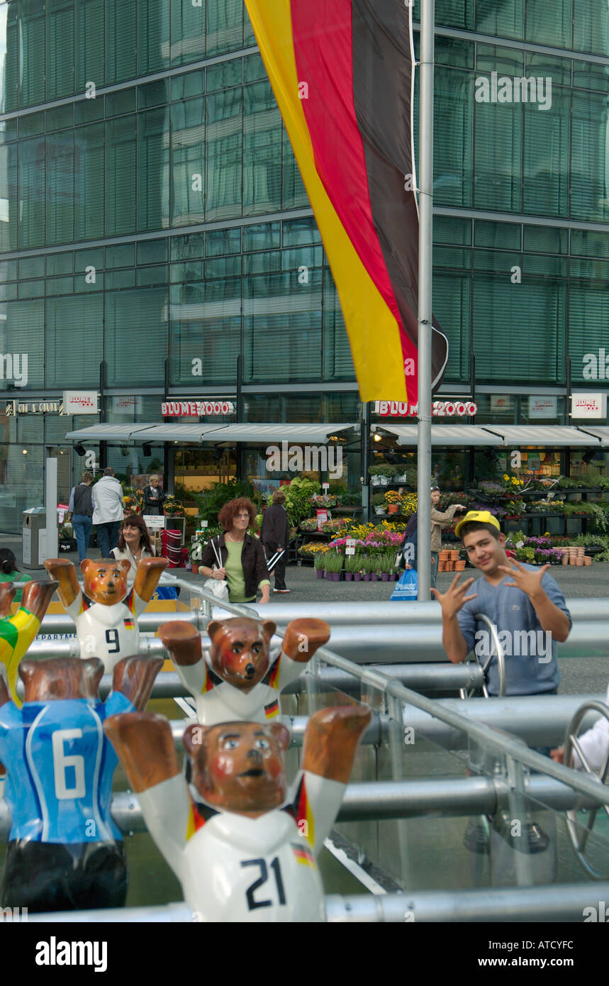 Ragazzi che giocano a calcio al tavolo di grandi dimensioni nel calcio Neue Kranzler Eck. Bandiera tedesca in background. Charlottenburg di Berlino 2005 Foto Stock