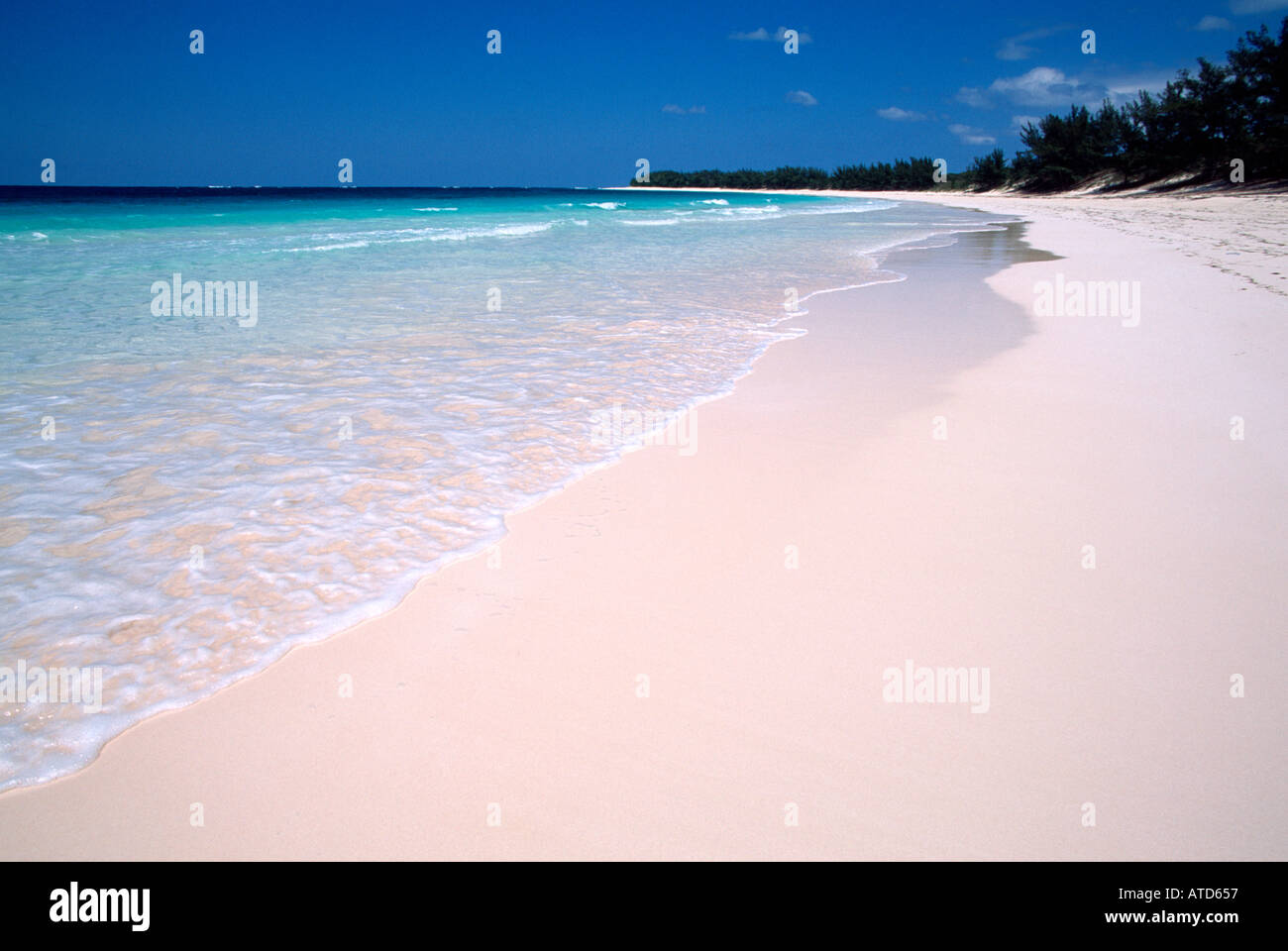 Il turchese del mare dei Caraibi incontra incontaminate di sabbia bianca su una spiaggia in Bahamas Foto Stock