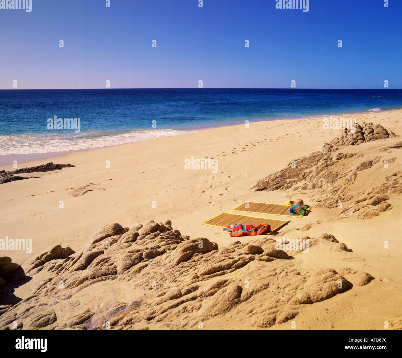 Una spiaggia mat giace sulla sabbia sulla spiaggia rocciosa di Cabo San Lucas Messico Foto Stock