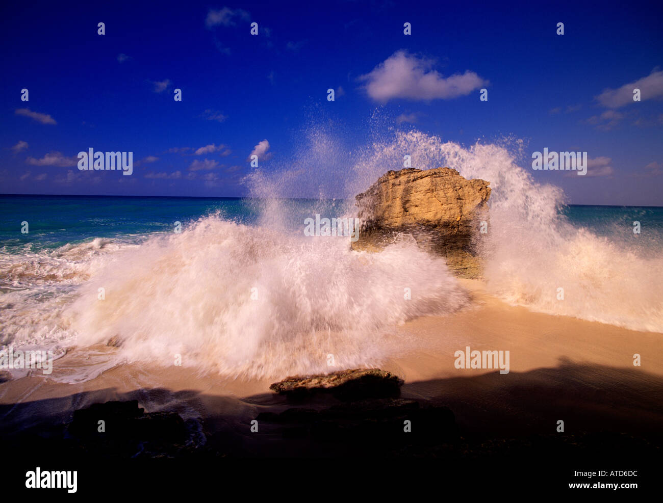 Onde infrangersi intorno a formazioni rocciose nel surf su Cupecoy Bay Beach di St Maarten Foto Stock