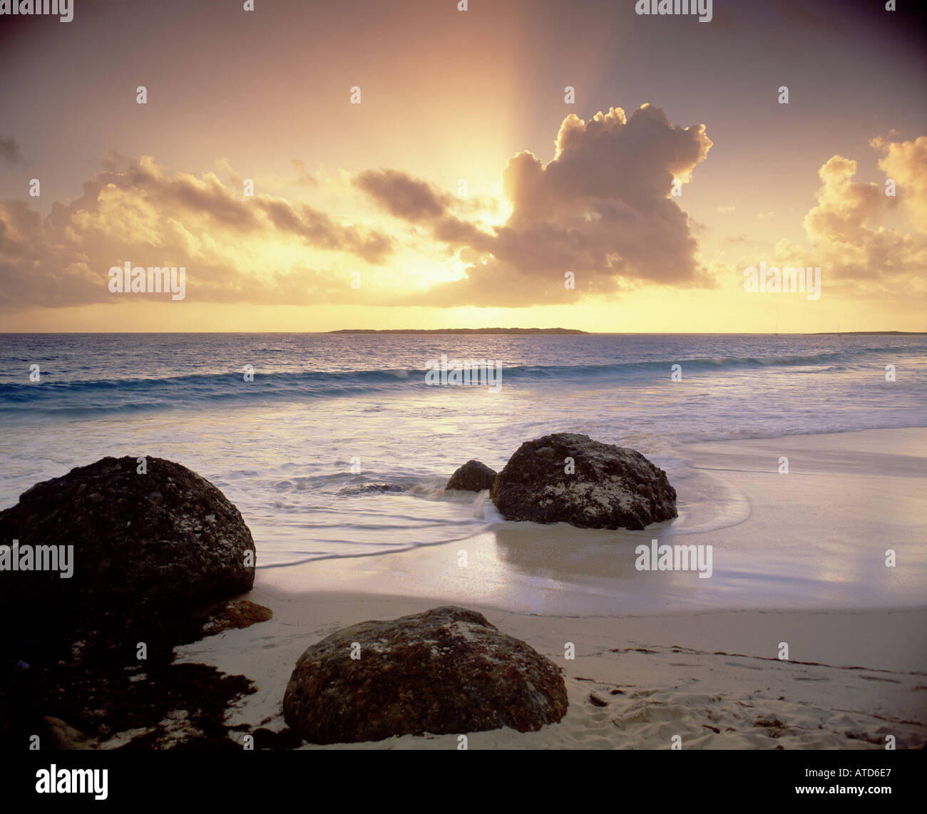 Il sole comincia a impostare sulla spiaggia rocciosa di Baie Orientale St Maarten Foto Stock