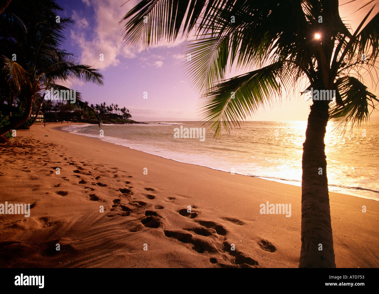 Il sole tramonta su orme nella sabbia sulla spiaggia di Kaanapali di Maui Hawaii Foto Stock