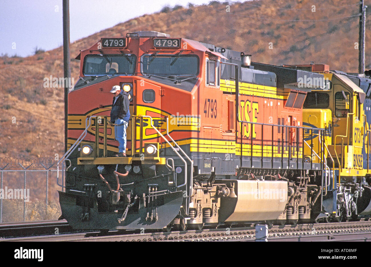 BNSF treno ingegnere controllo fuori l'aria i tubi flessibili del freno prima che il tecnico prende il treno verso il basso il Cajon Pass Foto Stock