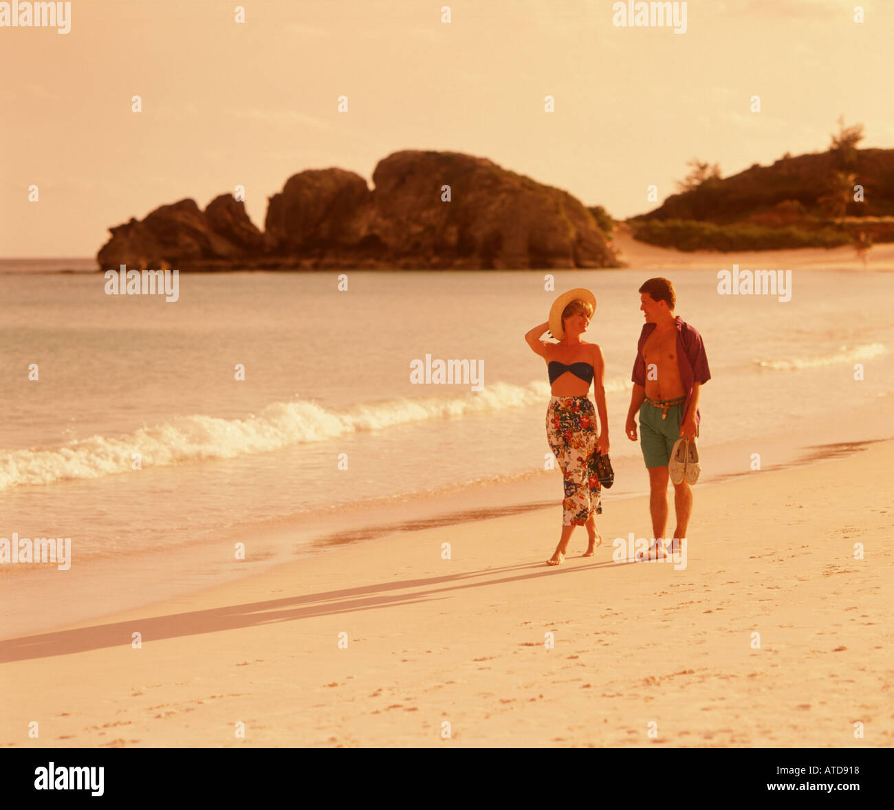 Un paio di passeggiate mano nella mano lungo una spiaggia in Bermuda Foto Stock