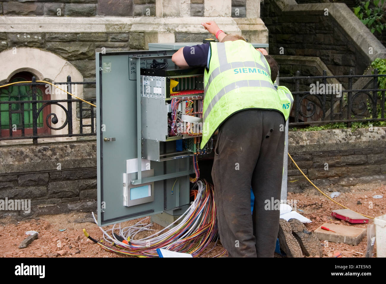 Telefono gli ingegneri che lavorano su una scatola di giunzione centrale di Cardiff Regno Unito Foto Stock