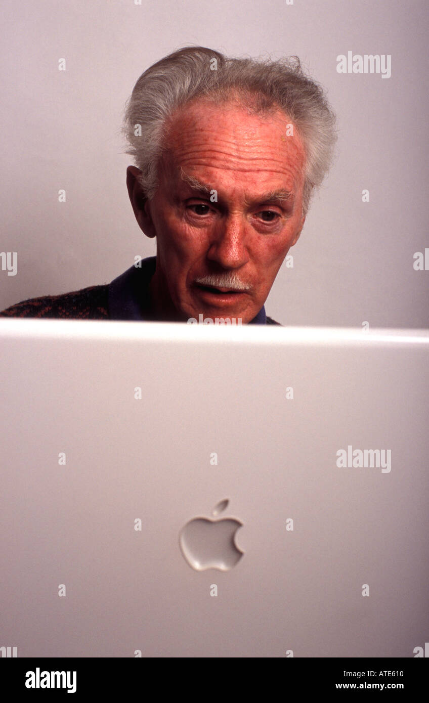 68 anno vecchio usando un Apple computer portatile per navigare in internet, Londra, Inghilterra. Foto Stock