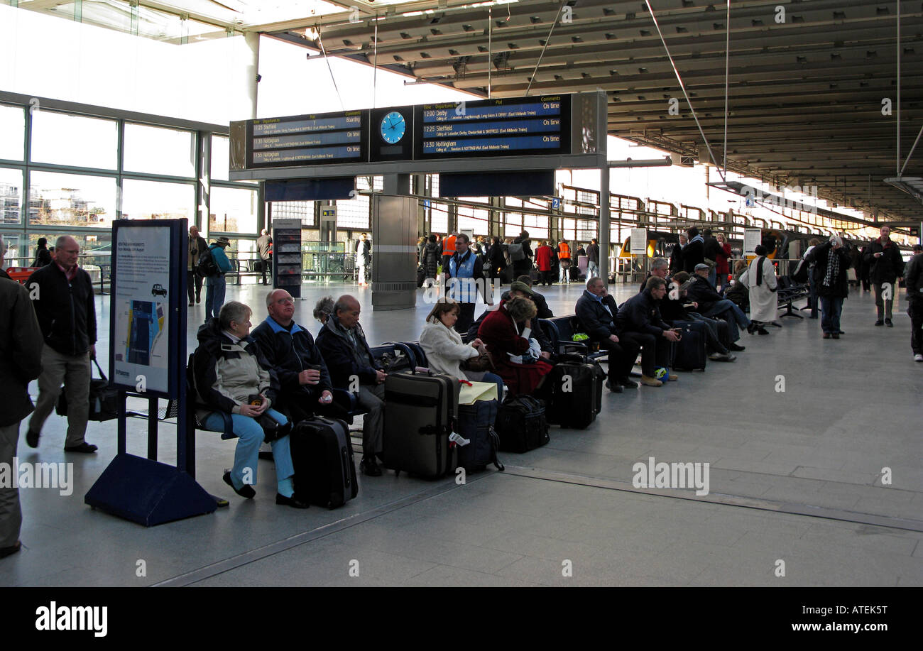 I passeggeri seduti e in piedi a St Pancras rail station di Londra, Regno Unito, Europa Foto Stock