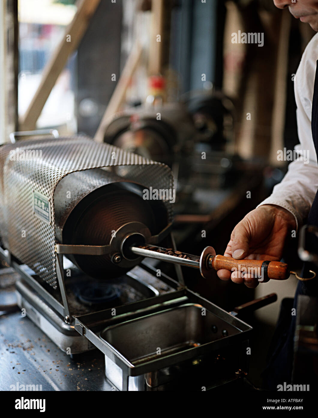 L'uomo la tostatura i chicchi di caffè Foto Stock