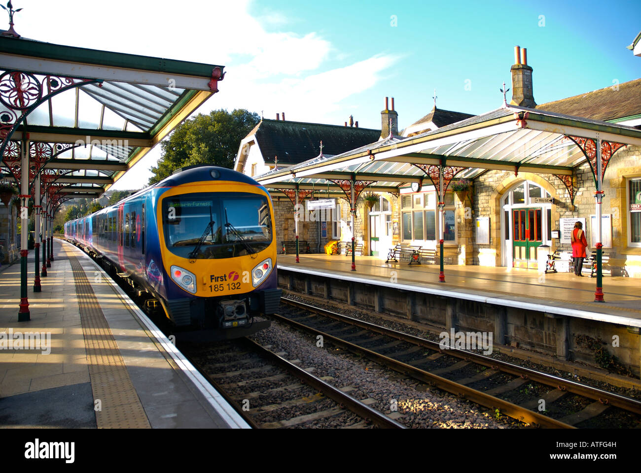 La stazione ferroviaria e il treno a Grange-over-Sands, sulla linea Furness, con rinnovato le tettoie, Cumbria, England Regno Unito Foto Stock