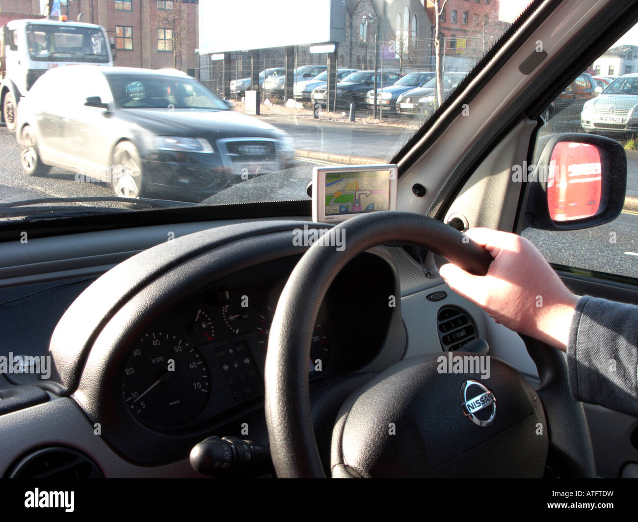 Man mano sulla parte superiore di un volante di un furgone di guida attraverso il Belfast City Center seguenti sat nav le direzioni Foto Stock