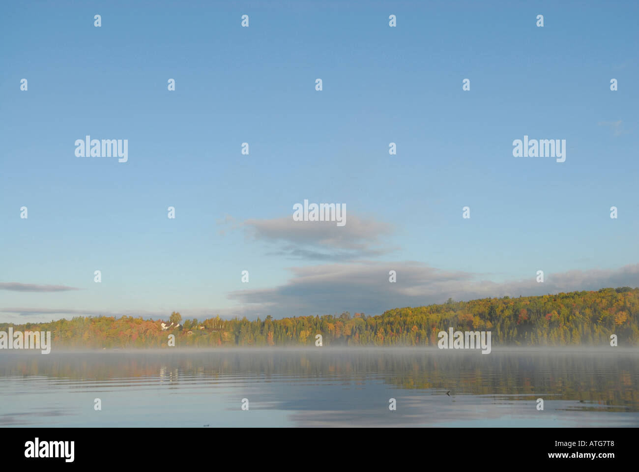 Immagine di stock di un lago con acqua come vetro su di un inizio di mattina autunnale con nebbia in New Brunswick Canada Foto Stock