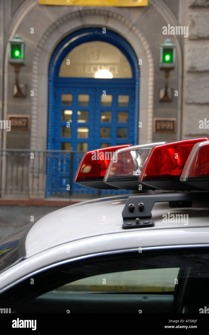 Luci sul tetto di una macchina della polizia parcheggiata di fronte un quartiere della stazione di polizia Foto Stock Luci sul tetto di una macchina della polizia parcheggiata di fronte un quartiere della stazione di polizia Foto Stock