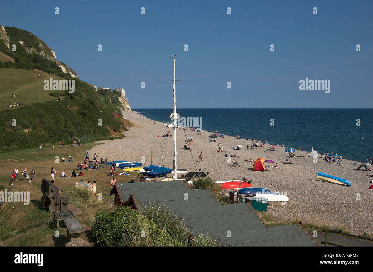 La spiaggia di ciottoli a Branscombe, East Devon, in Inghilterra con i vacanzieri e barche su una giornata d'estate. Foto Stock