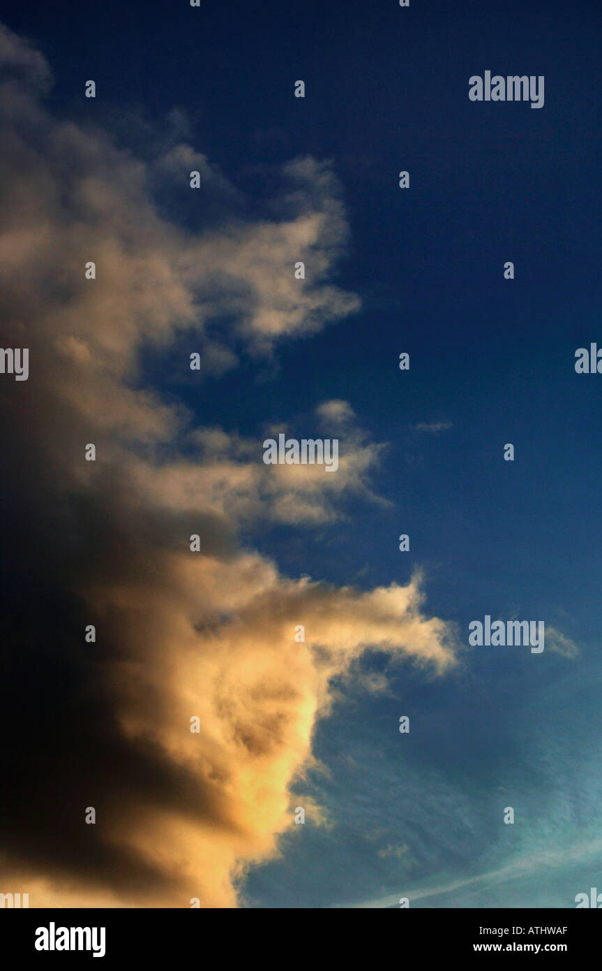 Golden surreale formazioni Cloud insieme contro un azzurro cielo di sera Foto Stock