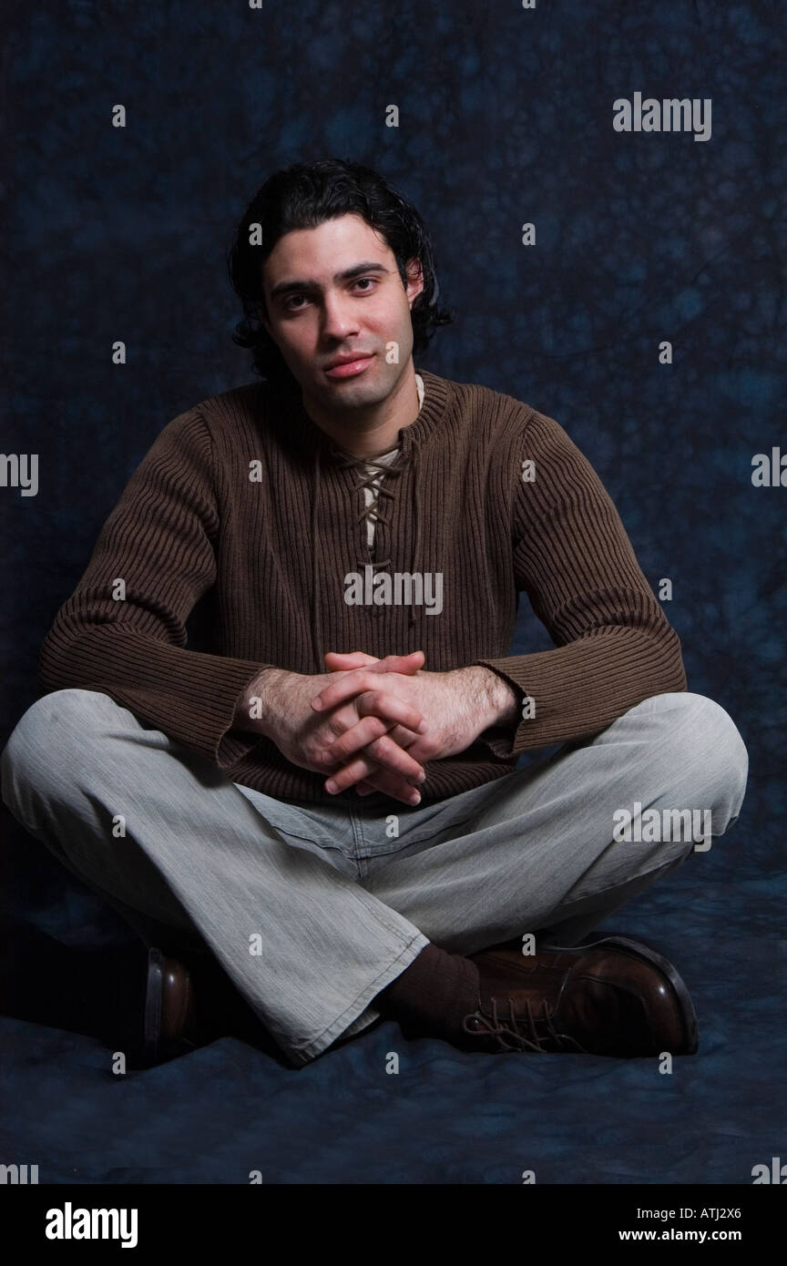 Uomo seduto sul pavimento con le gambe incrociate Foto Stock