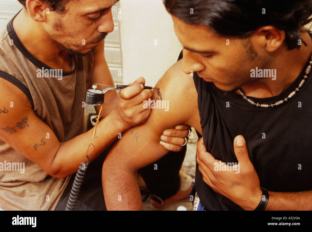 Un tatuaggio palestinese artista lavora su un cliente a Shatila campo profughi a Beirut Libano Foto Stock