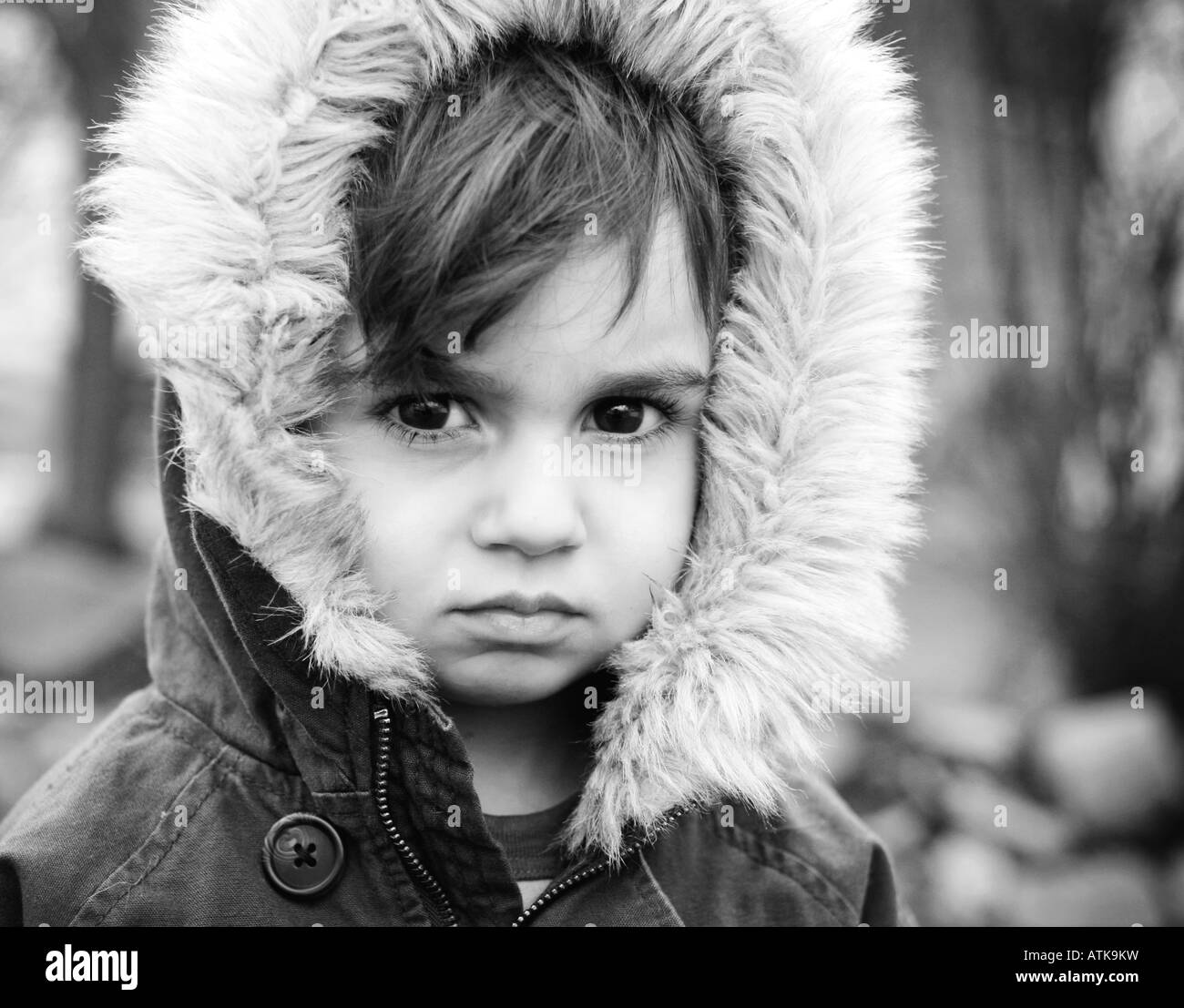 Bambino con cappa pelliccia con sguardo serio Foto Stock