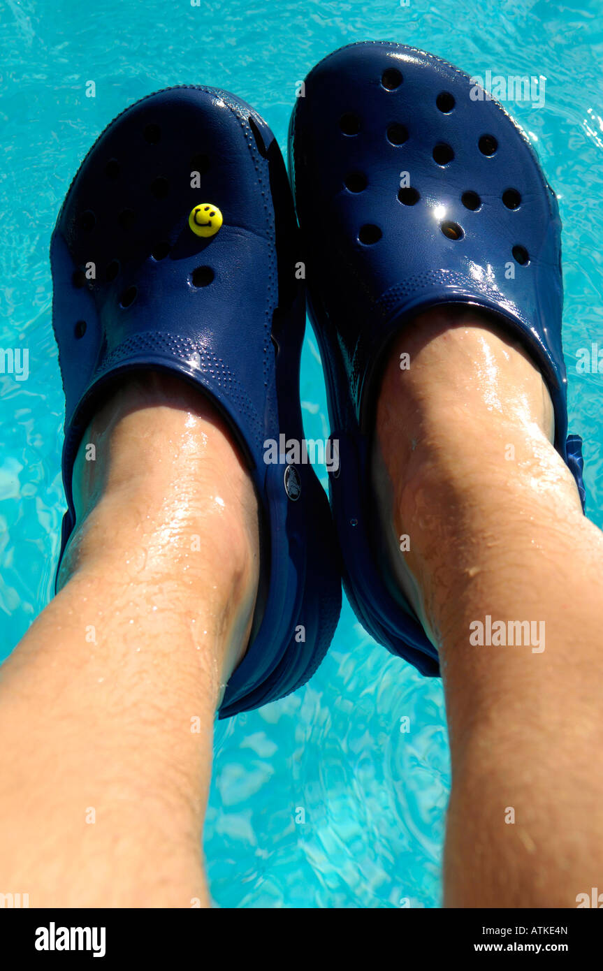 Crocs blu scarpe da spiaggia piscina scarpe flottante vacanze colore blu  coppia orizzontale piedi gambe l'uomo maschio Foto stock - Alamy